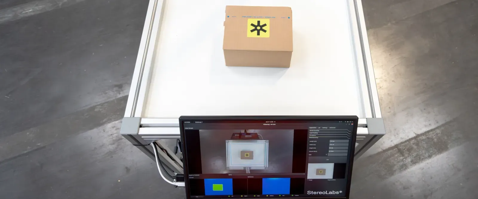 Parcel dimensioning station with a ZED camera above a parcel