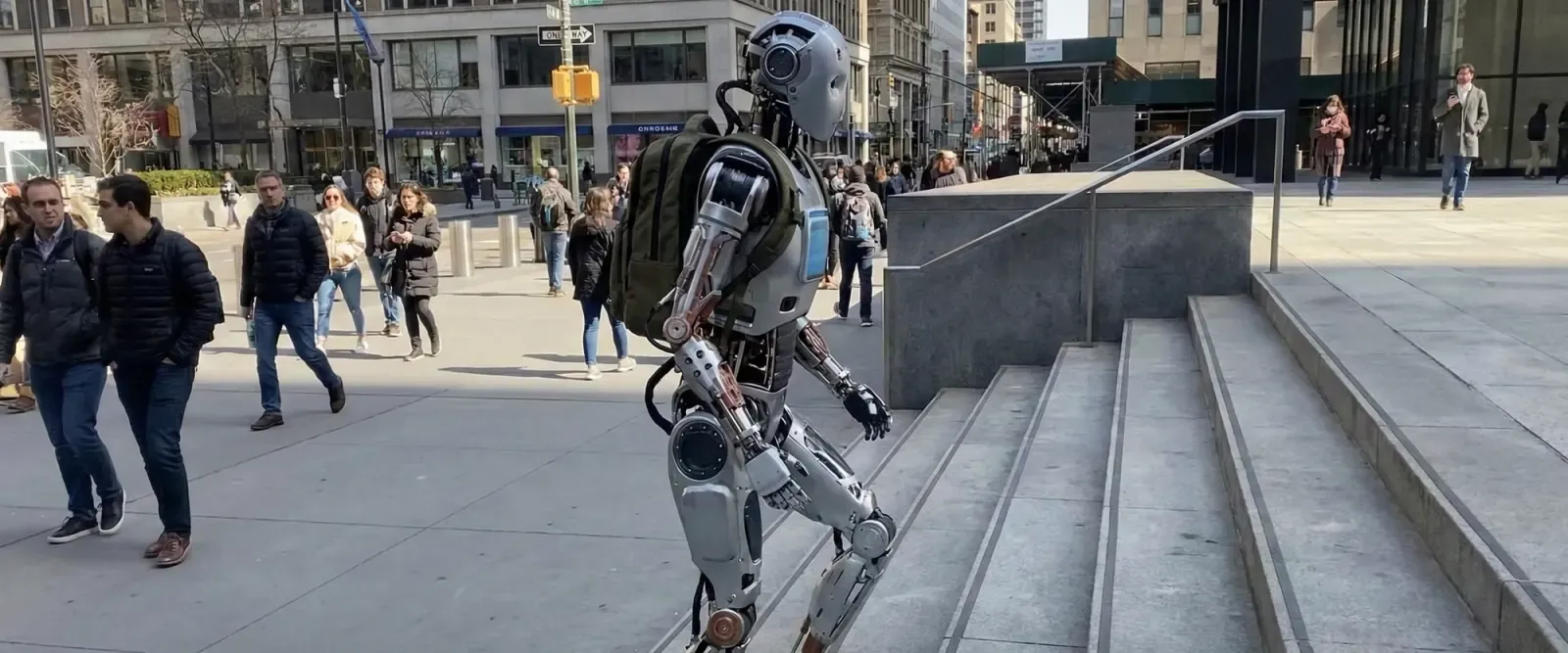Humanoid robot walking up a staircase in a city street
