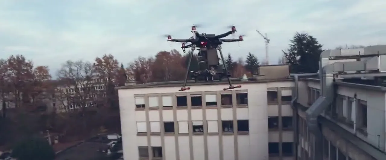 Hexacopter drone carrying a ZED camera, flying above a building